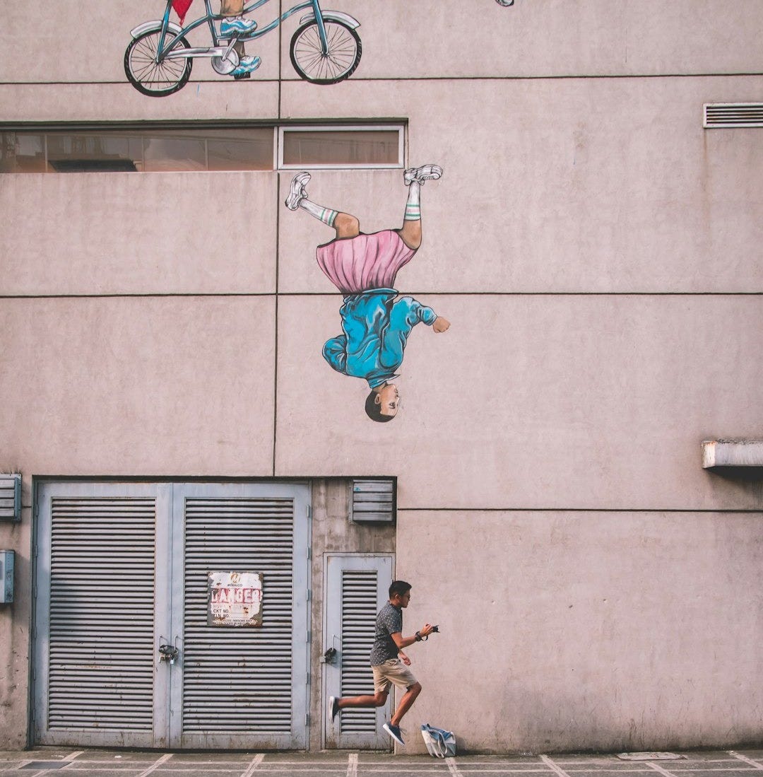 man jumping beside building during daytime