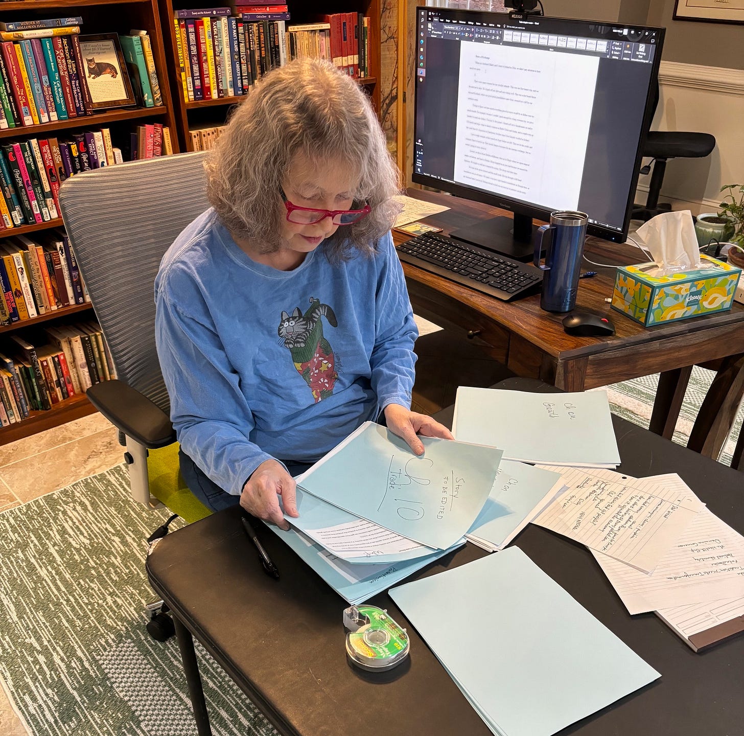 A women is working on some papers at her desk.