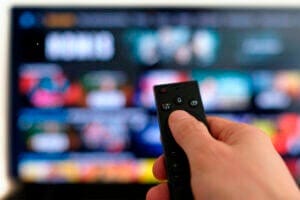 Remote control and screen - binge watching the favorite TV show