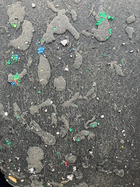 Smooth and shiny electric blue; close-up of a post-race car tyre; a big puffy pop-up building