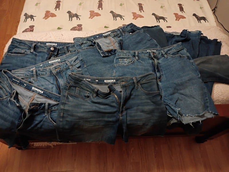 Cut-off jean shorts with pieces of longer jeans on a bed Cut-off jean shorts with pieces of longer jeans on a bed