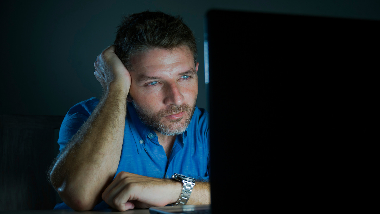 A man watching a computer screen. A man watching a computer screen.