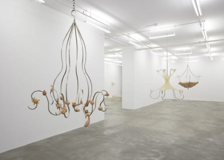 This may contain: an empty room with sculptures hanging from the ceiling and suspended by lights in the middle