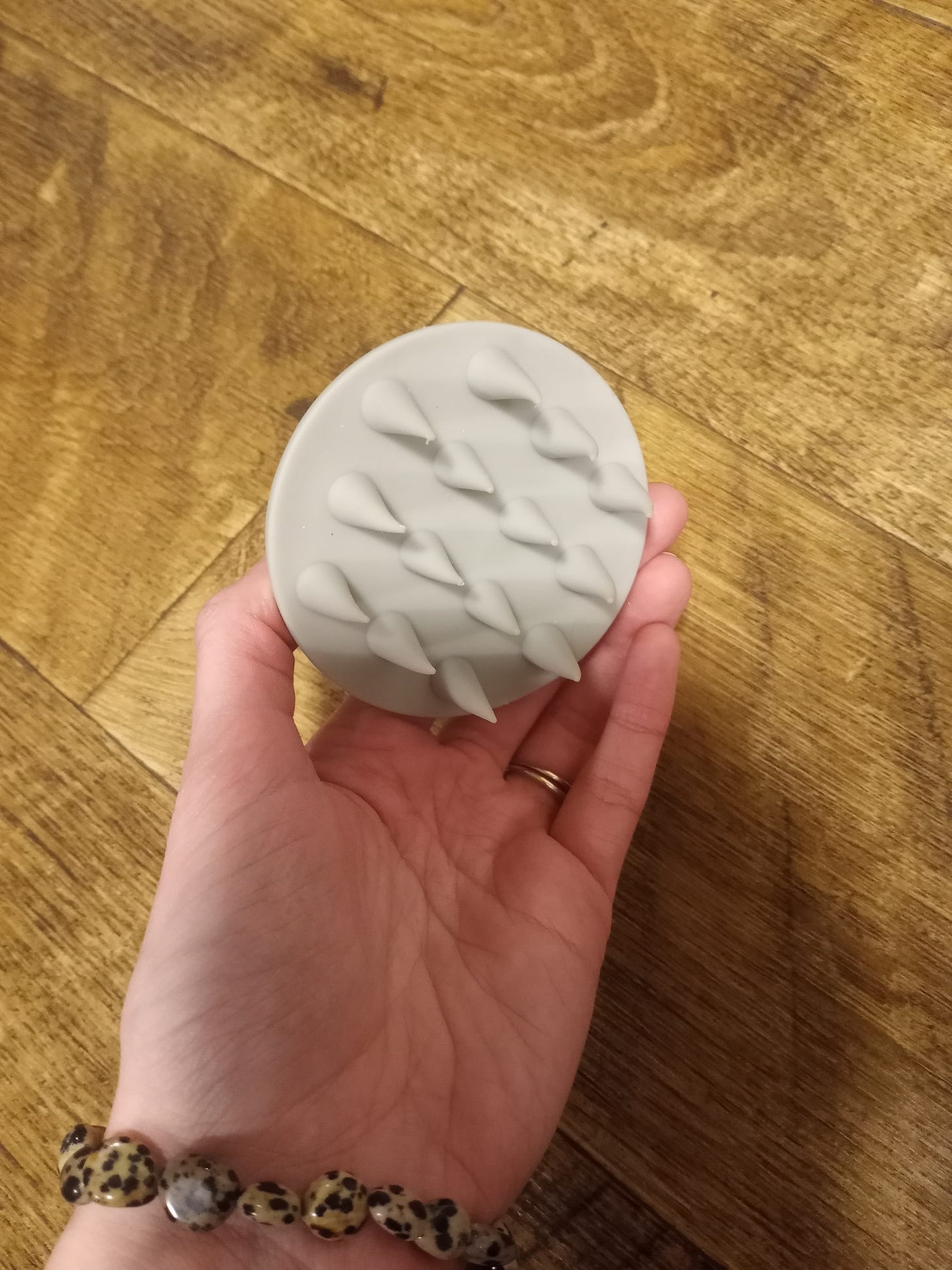 Picture of a gray silicone scalp scrubber