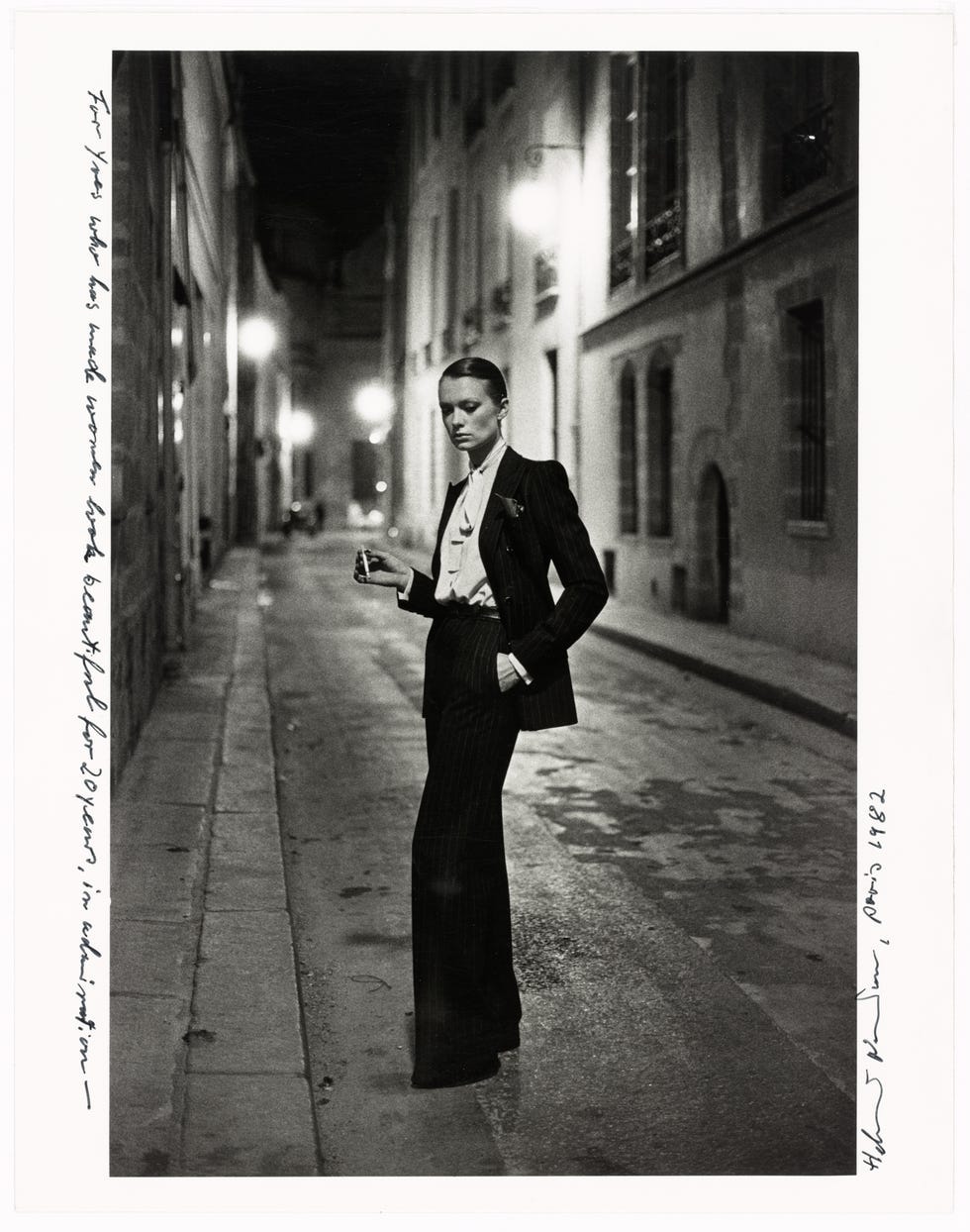 Person in tailored suit standing confidently in a dimly lit street at night. Person in tailored suit standing confidently in a dimly lit street at night.