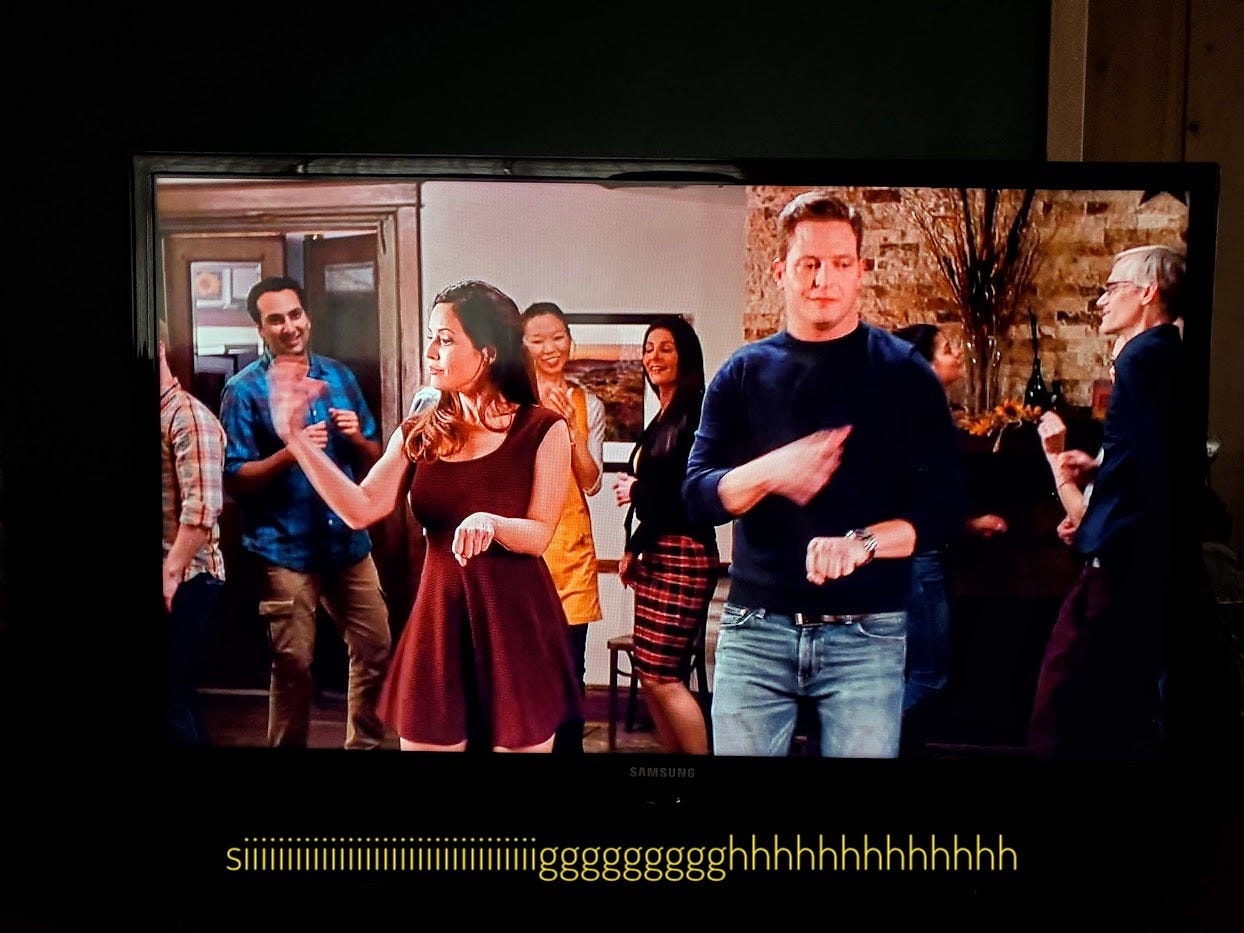 Katie and Chad pretending to push carts through the supermarket, as a dance, while people look on and clap, captioned with just a long sigh