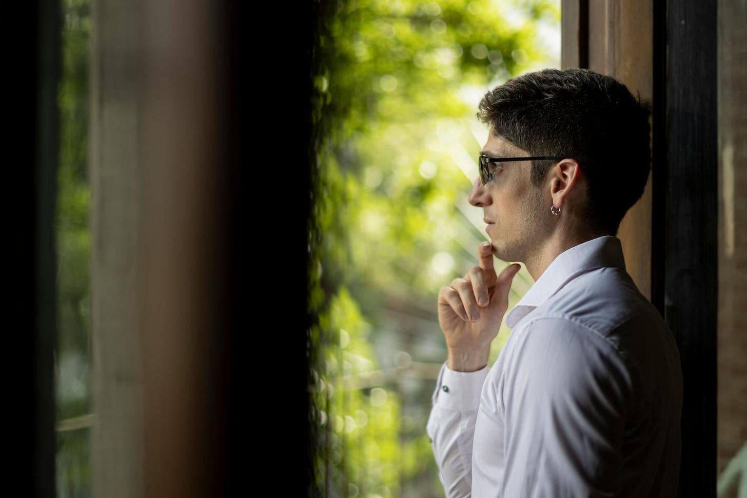 Man looking out a window while reflecting on reasonable boundaries
