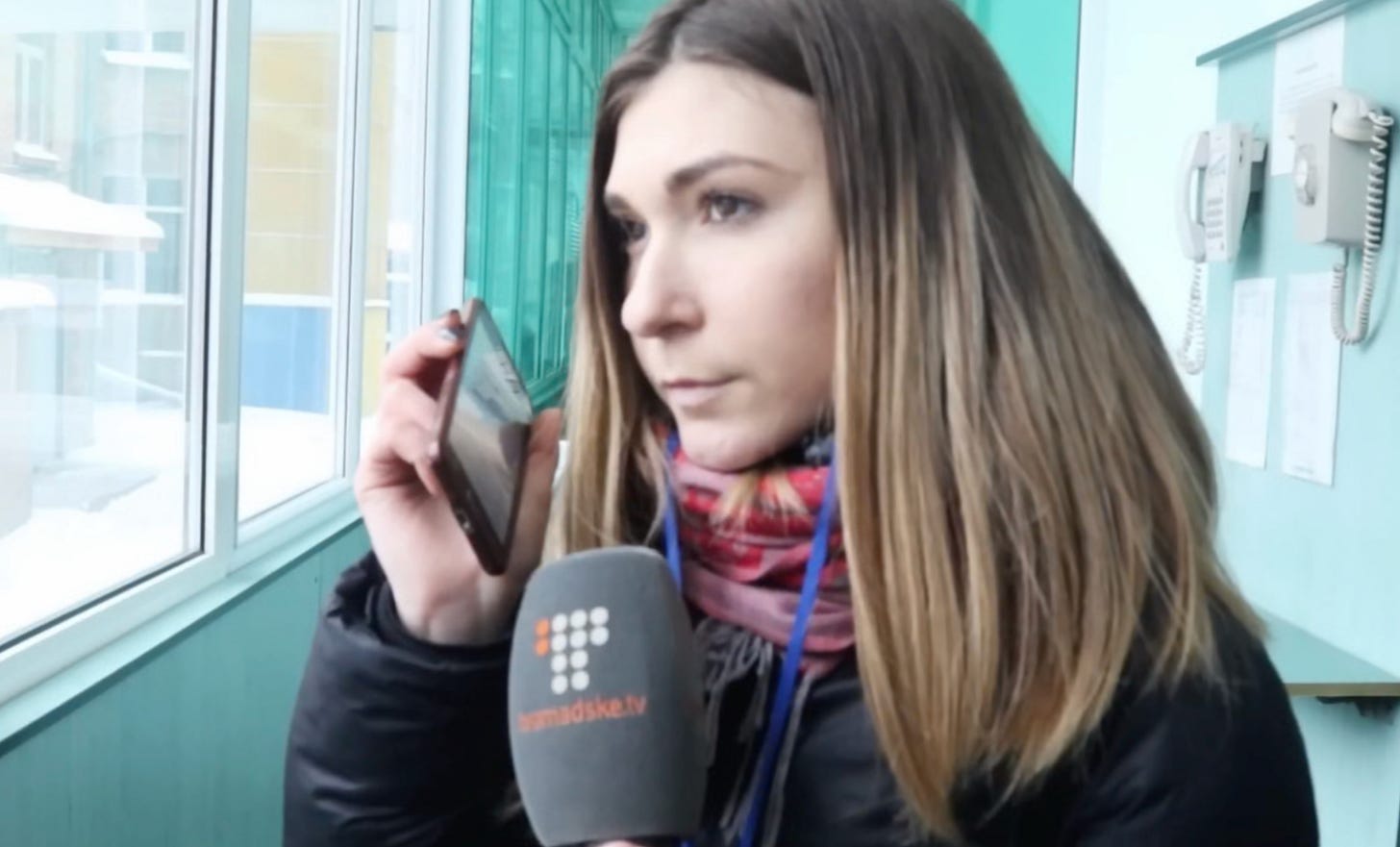 A person holding a phone and a microphone

AI-generated content may be incorrect.