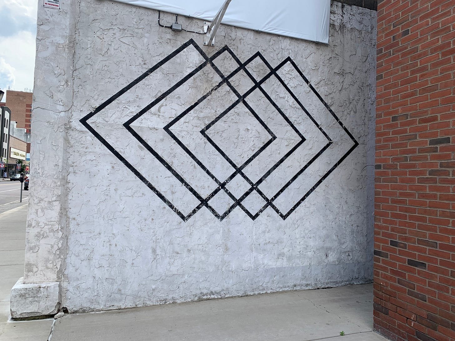 Mural of four black overlapping diamonds on a white background. Mural of four black overlapping diamonds on a white background.