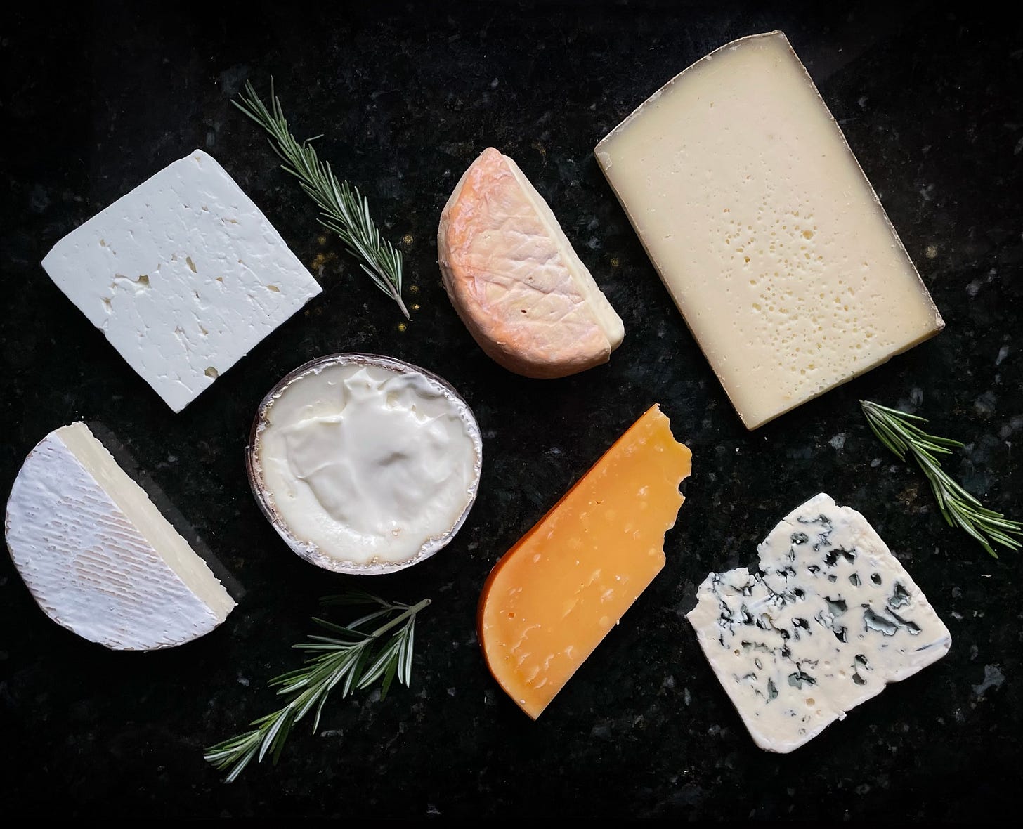 A selection of cheeses featuring various styles and textures A selection of cheeses featuring various styles and textures