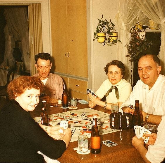 This may contain: a group of people sitting around a table with cards and beer bottles on the table