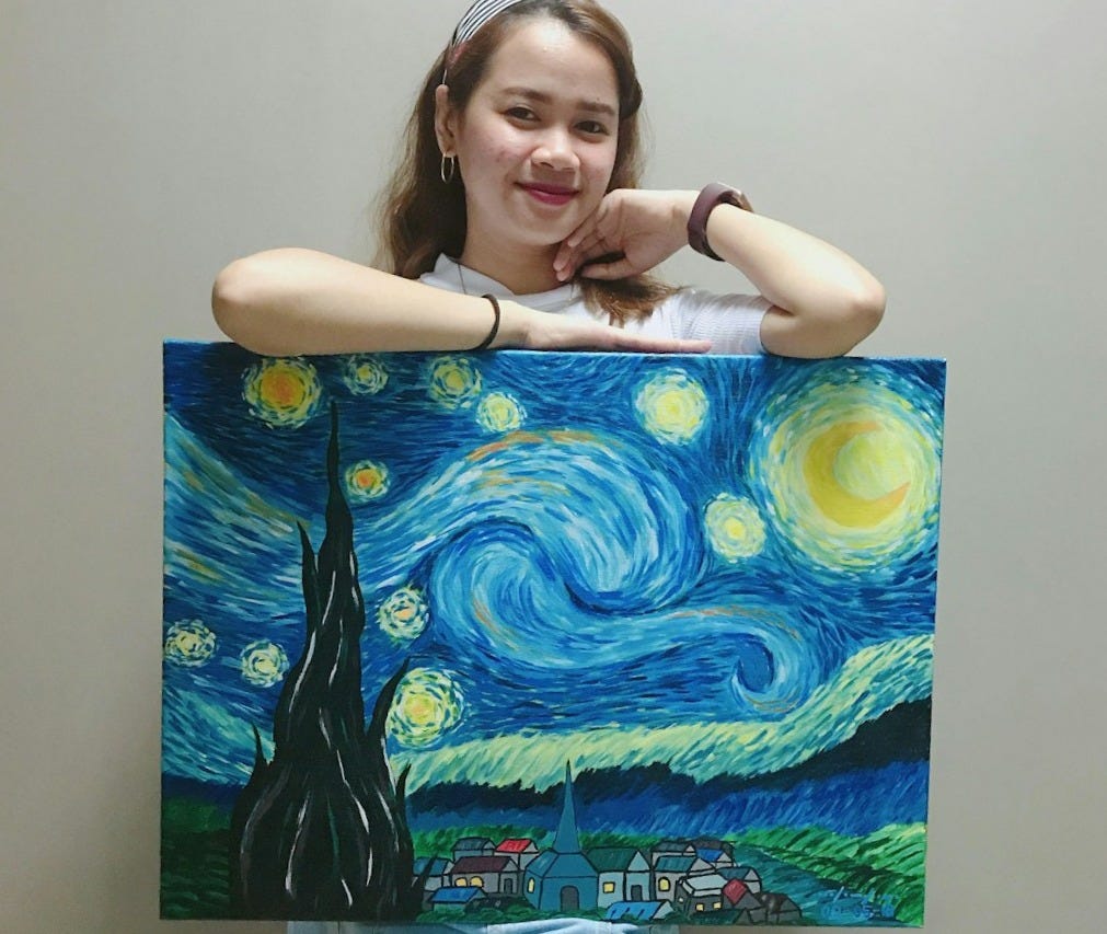 smiling woman standing and holding Starry Night painting by Vincent Van Gogh