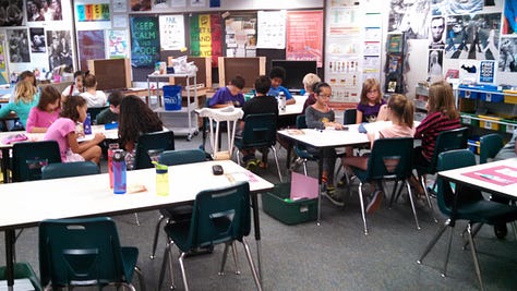 Students working on various projects throughout a classroom. 