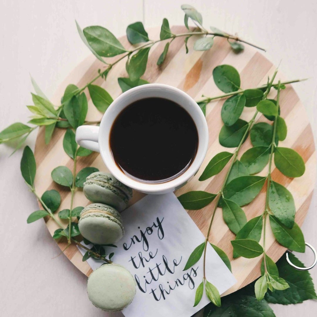 flat lay photography of leaves with cup of coffee and three macarons on chopping board flat lay photography of leaves with cup of coffee and three macarons on chopping board