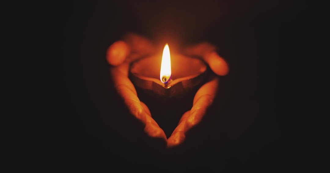 person holding lighted oil lamp