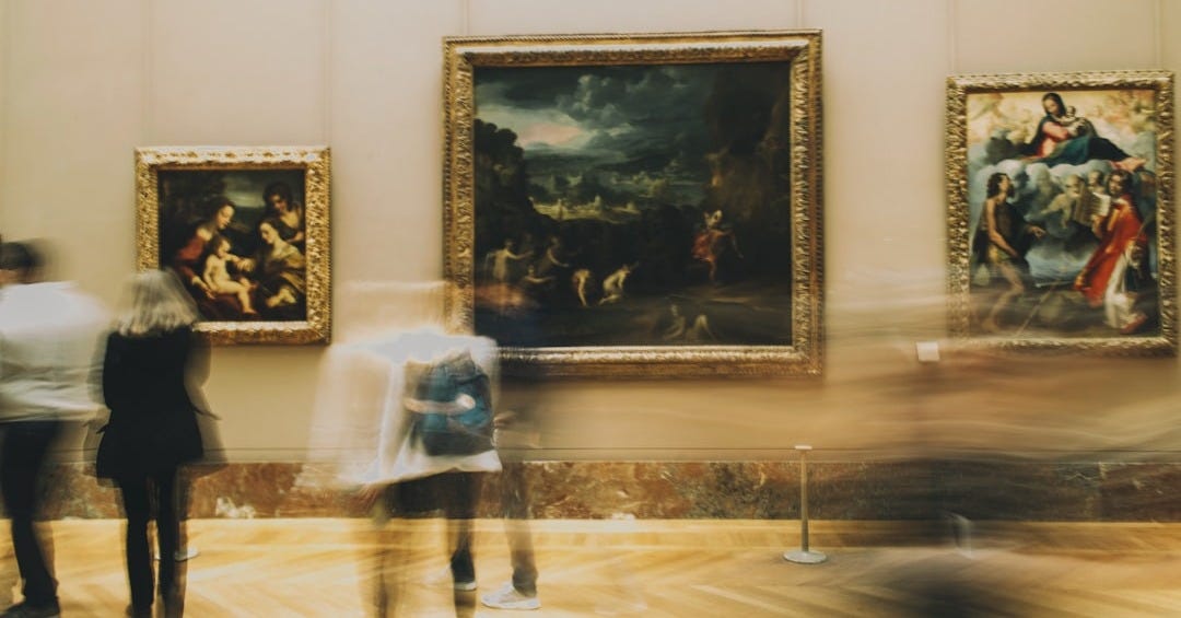 woman in white dress standing near painting