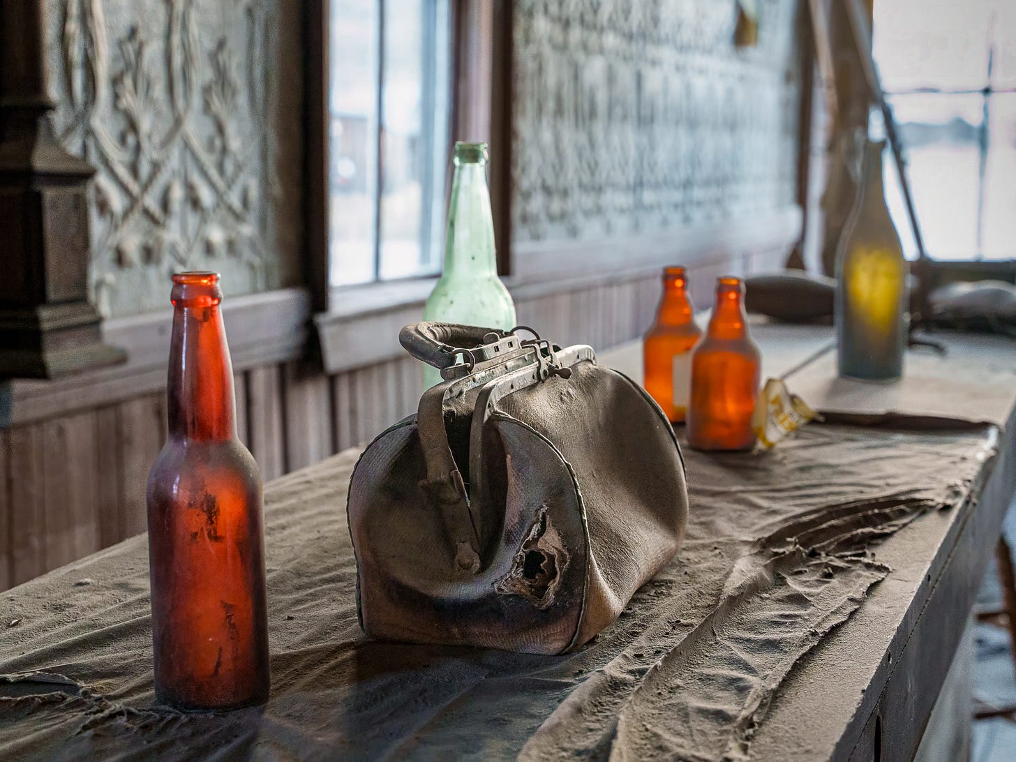 A dusty counter with bottles and a bag in Bodie State Historic Park in California.