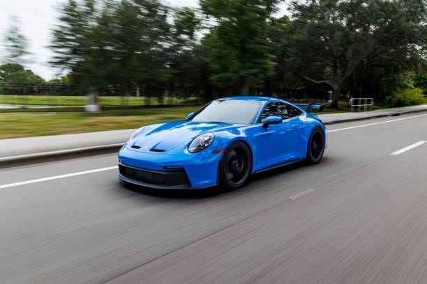 Modern blue Porsche 911 GT3 sportscar in motion Saint Petersburg, United States – June 05, 2022: A modern blue Porsche 911 GT3 sportscar in motion porsche stock pictures, royalty-free photos & images