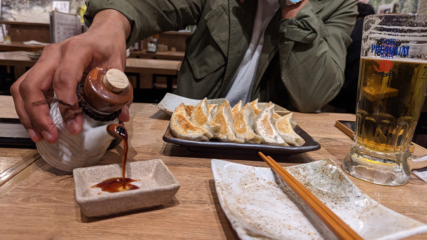 man in izakaya in tokyo with gyoza beer and sauce