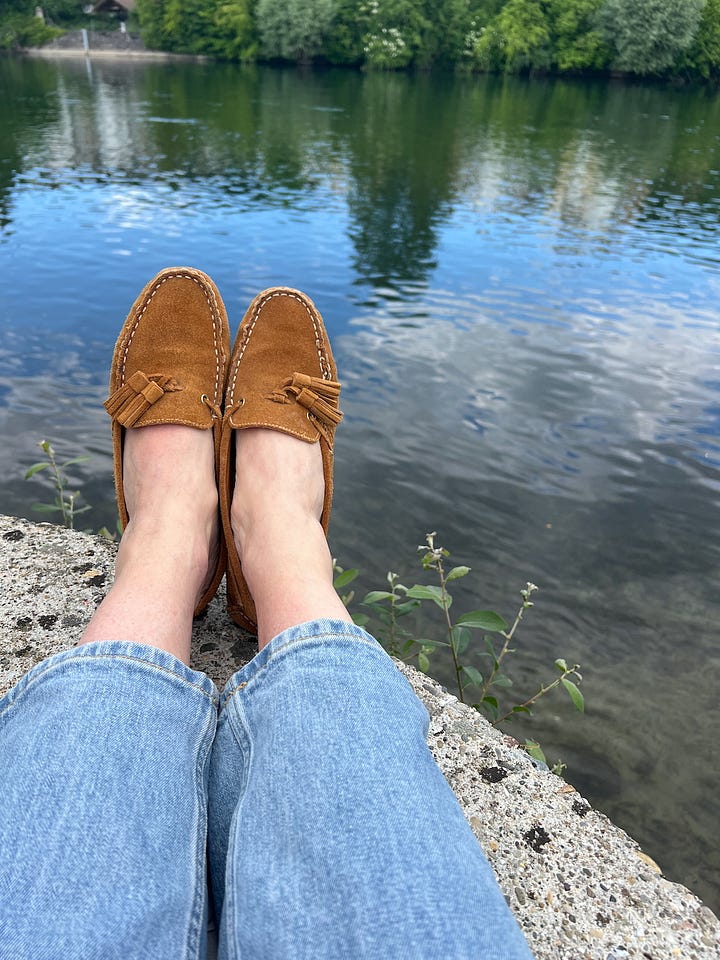 left: poppies and daisies in a field of wildflowers; right, jeans-clad legs with suede loafers, stretched out next to a river