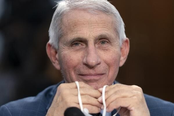FILE - Dr. Anthony Fauci, Director of the National Institute of Allergy and Infectious Diseases, holds his face mask in his hands as he attends a House Committee on Appropriations subcommittee hearing on about the budget request for the National Institutes of Health, May 11, 2022, on Capitol Hill in Washington.  Fauci, the government’s top infectious disease expert, says he plans to retire by the end of President Joe Biden’s term in January 2025. Fauci, 81, became director of the National In