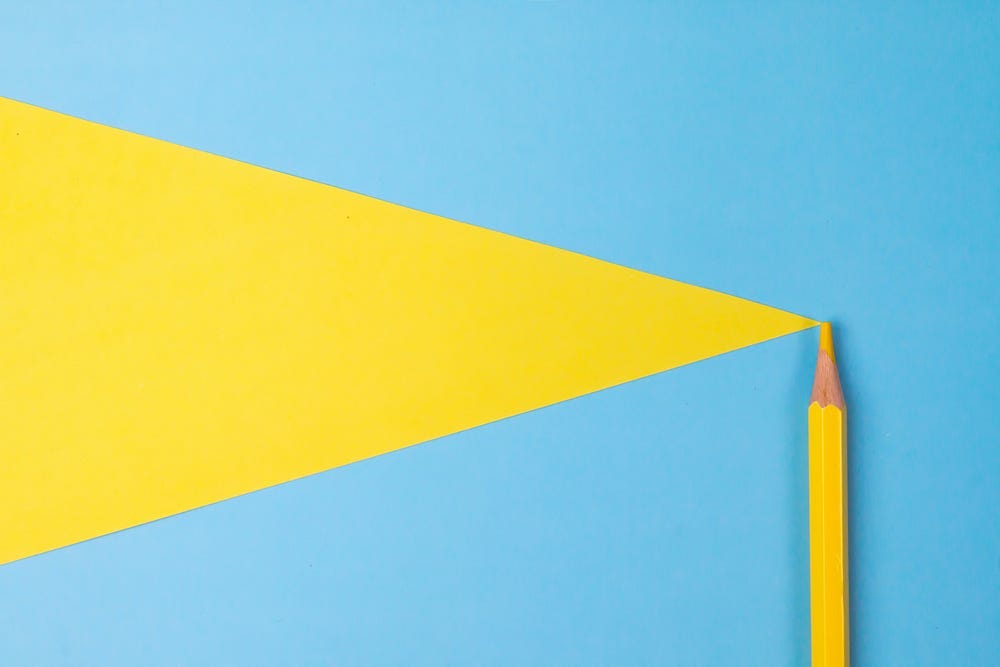 yellow pencil trailing a yellow triangle on a blue background