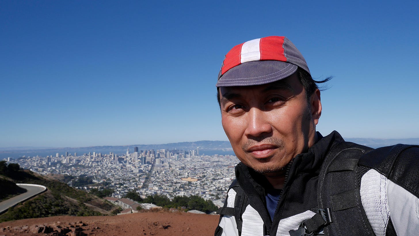 Selfie from the top of Twin Peaks in San Francisco, looking down upon the San Francisco skyline and the hills beyond.