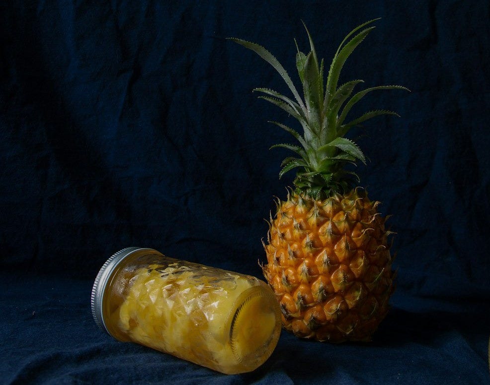 pineapple fruits near glass jars