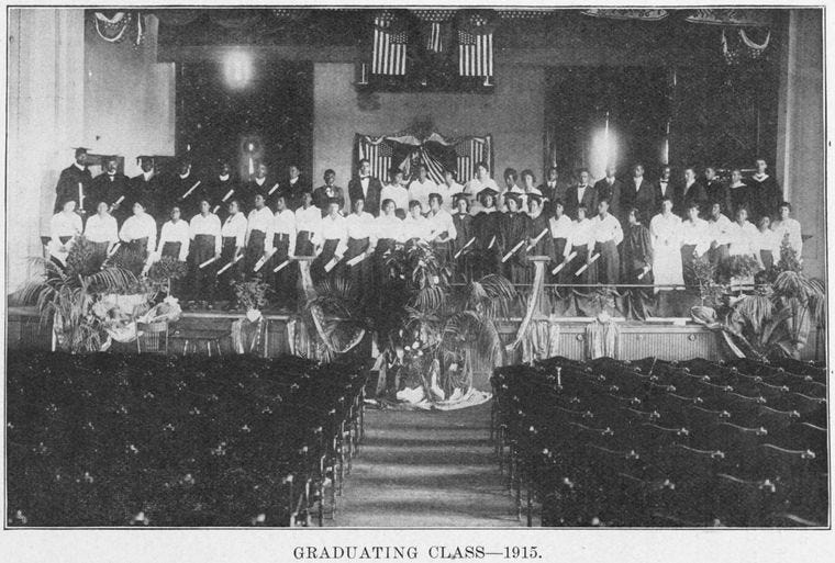 Photograph from 1915 of a graduating class on the stage of an auditorium