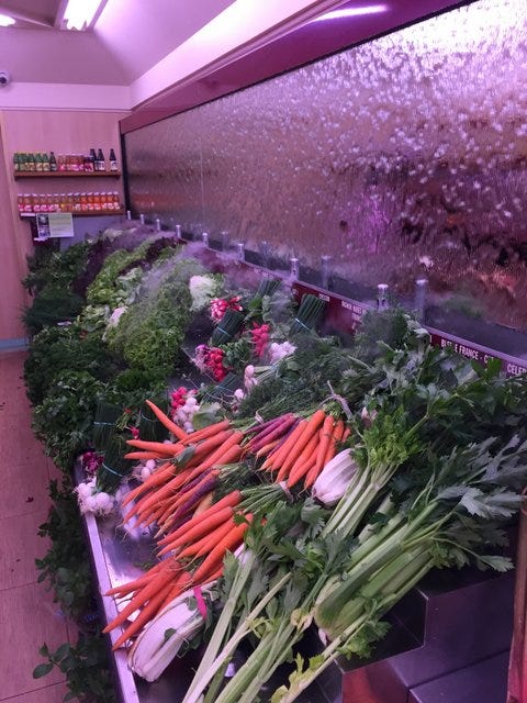 A primeur. Note the cooling spray on the vegetables, with water running down the mirror behind them A primeur. Note the cooling spray on the vegetables, with water running down the mirror behind them