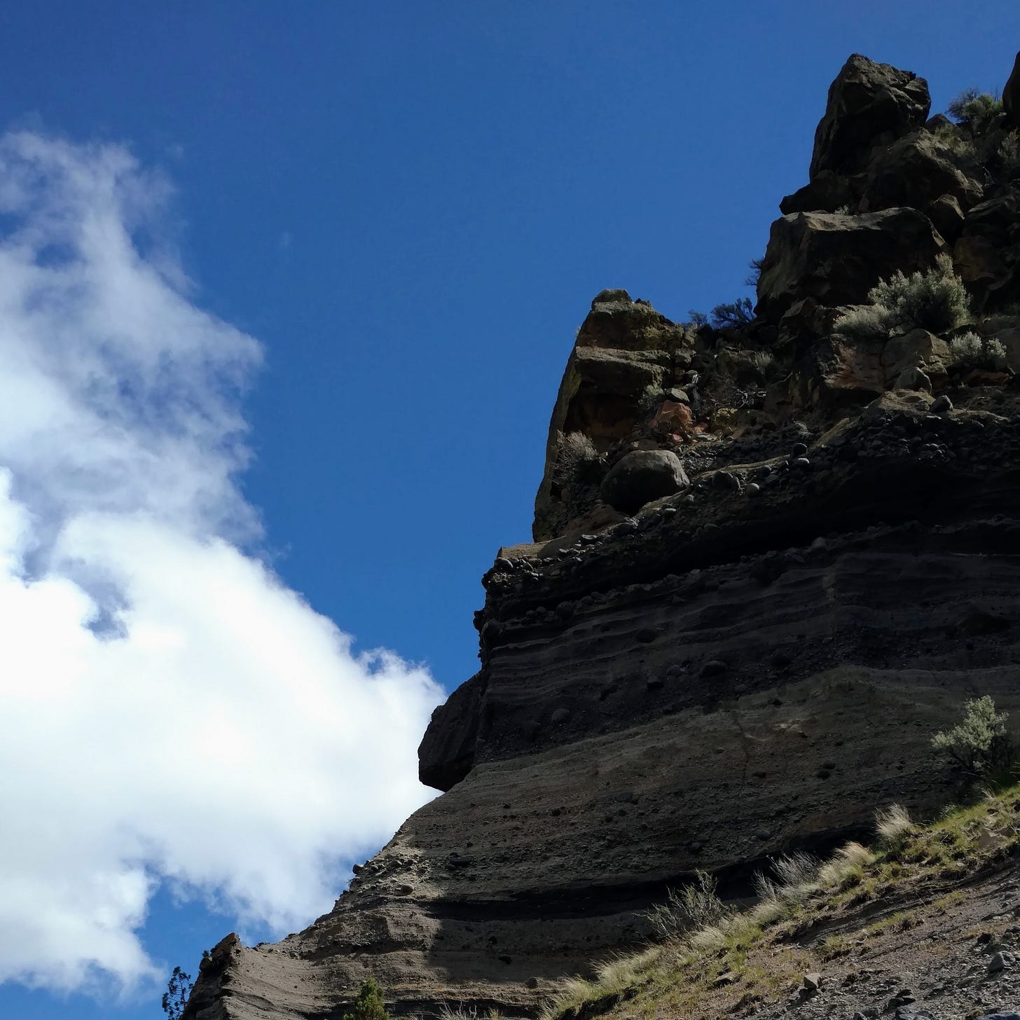 a rock formation against a cloudy blue sky