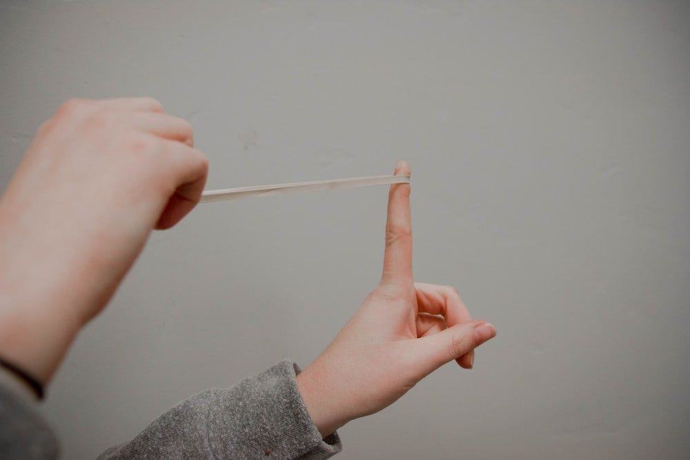 person holding rubberband person holding rubberband