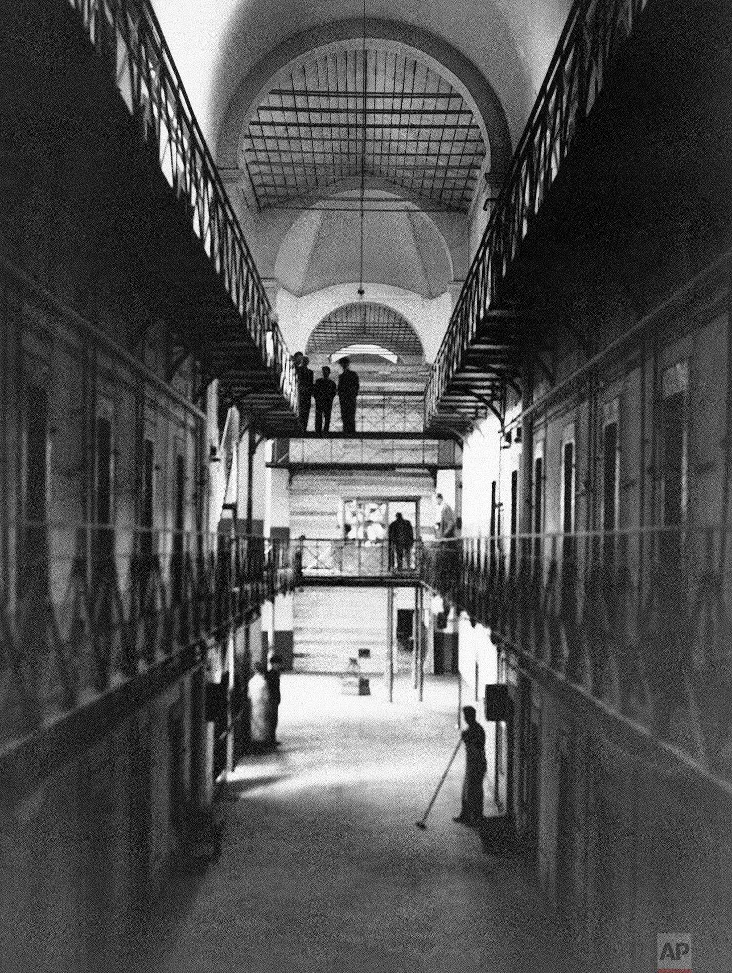 Inside the Nuremberg prison, August 1945: The austere cell block designated to house high-ranking Nazi war criminals awaiting their historic trial. A boarded-up section reserved for key defendants hints at the gravity of the impending proceedings.