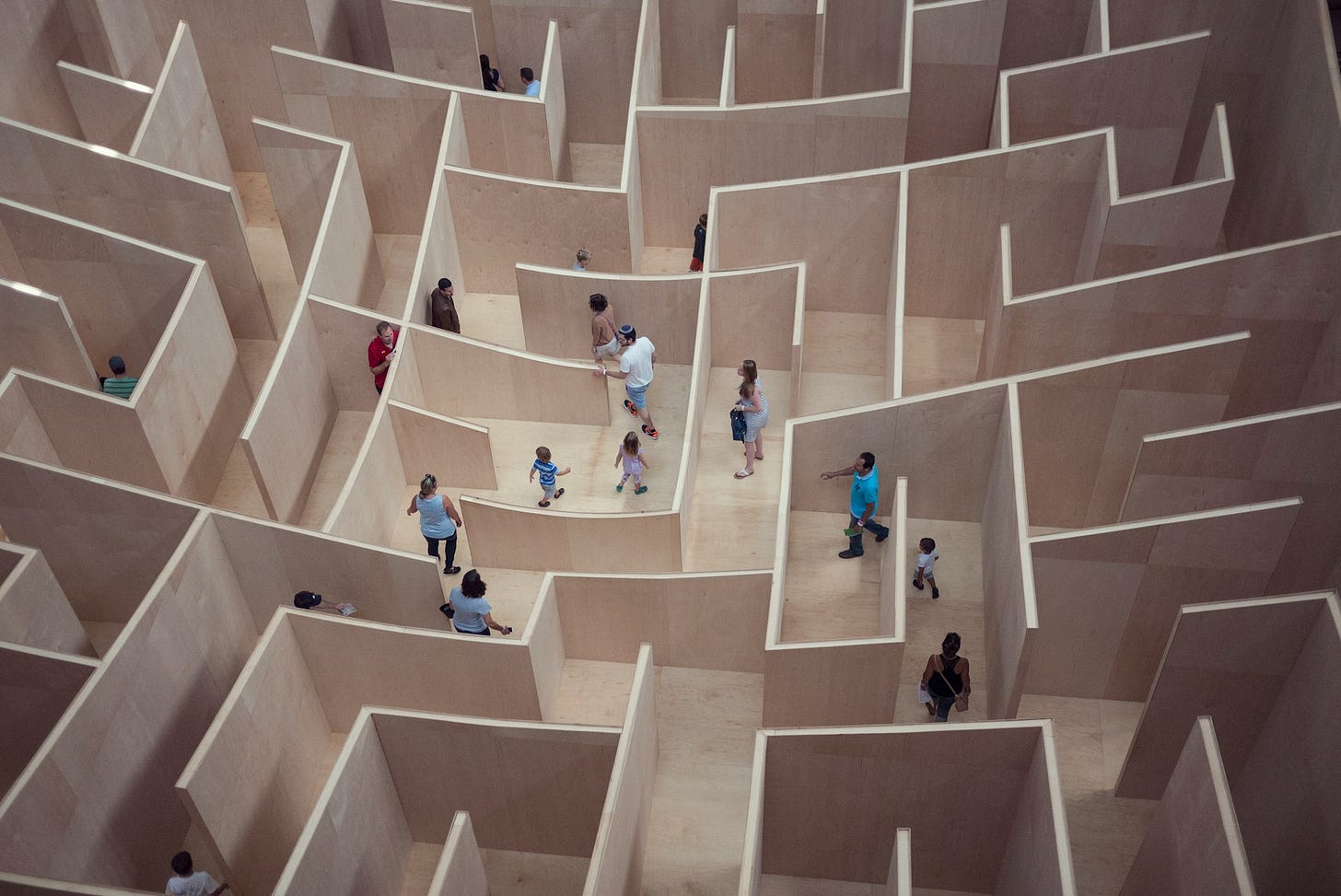 People walking in a large human-sized maze