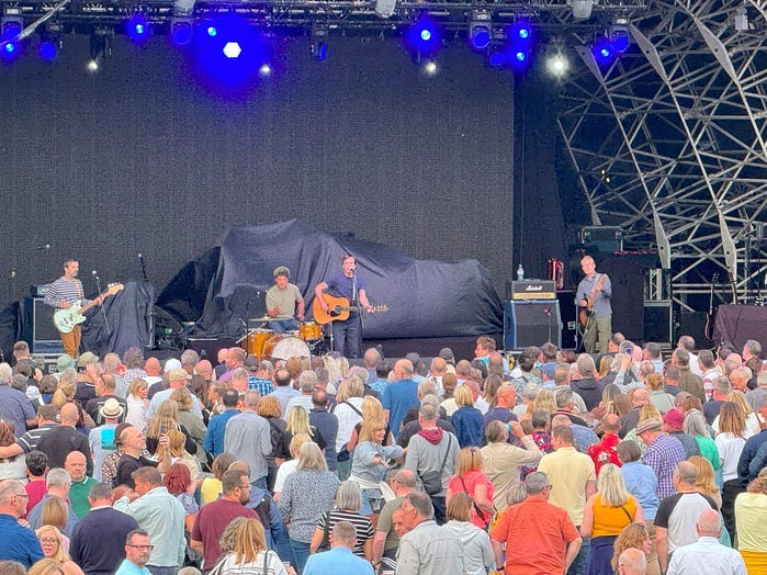 The Bluetones playing guitars and singing in front of a packed arena