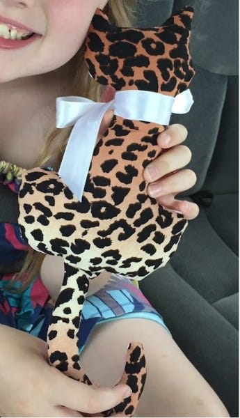 girl holding a handsewn stuffed cat