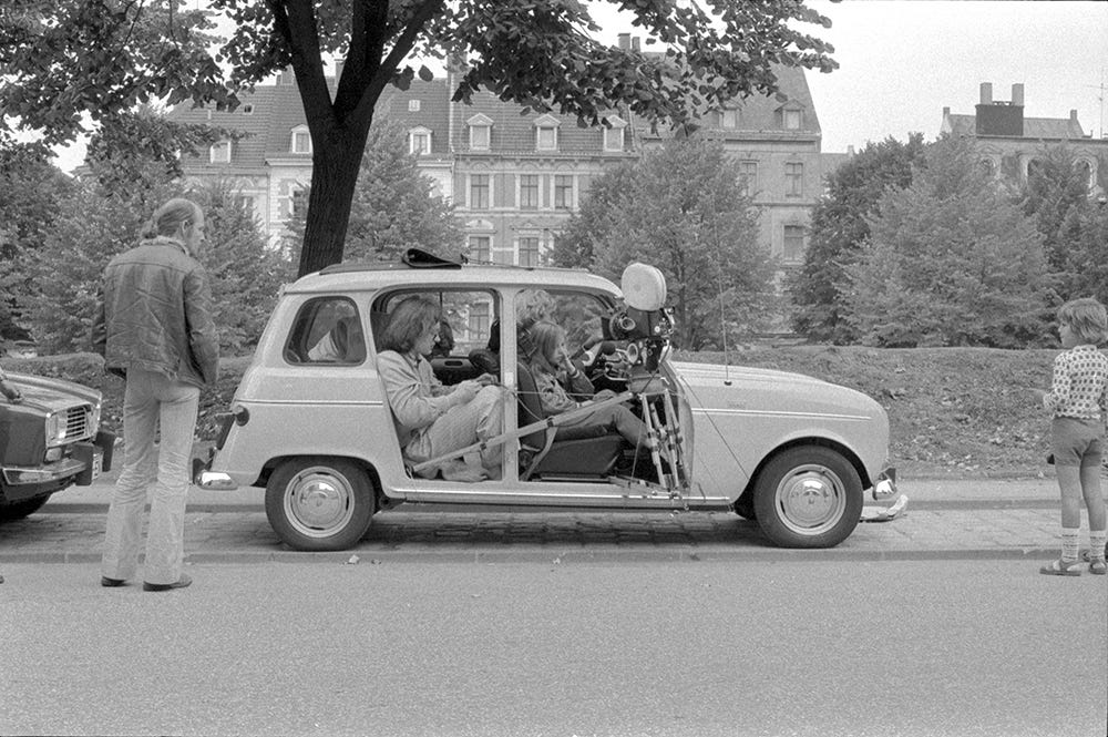 Wim Wenders operating a sketchy camera rig from the backseat while Robby Müller looks on Wim Wenders operating a sketchy camera rig from the backseat while Robby Müller looks on