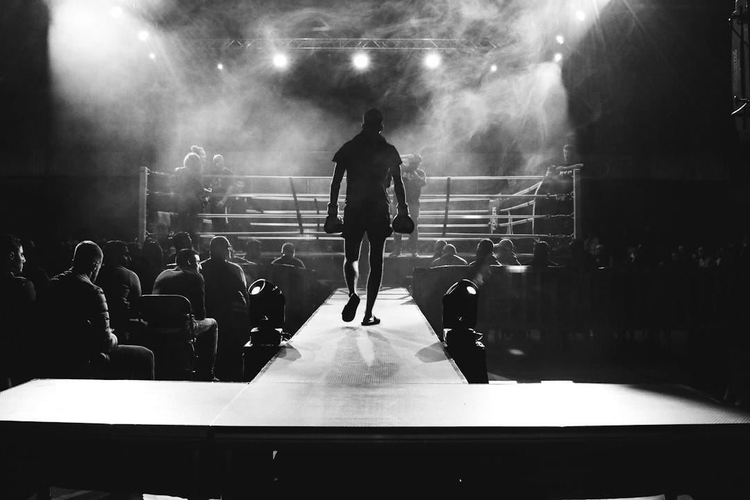 man standing and walking going on boxing ring surrounded with people man standing and walking going on boxing ring surrounded with people