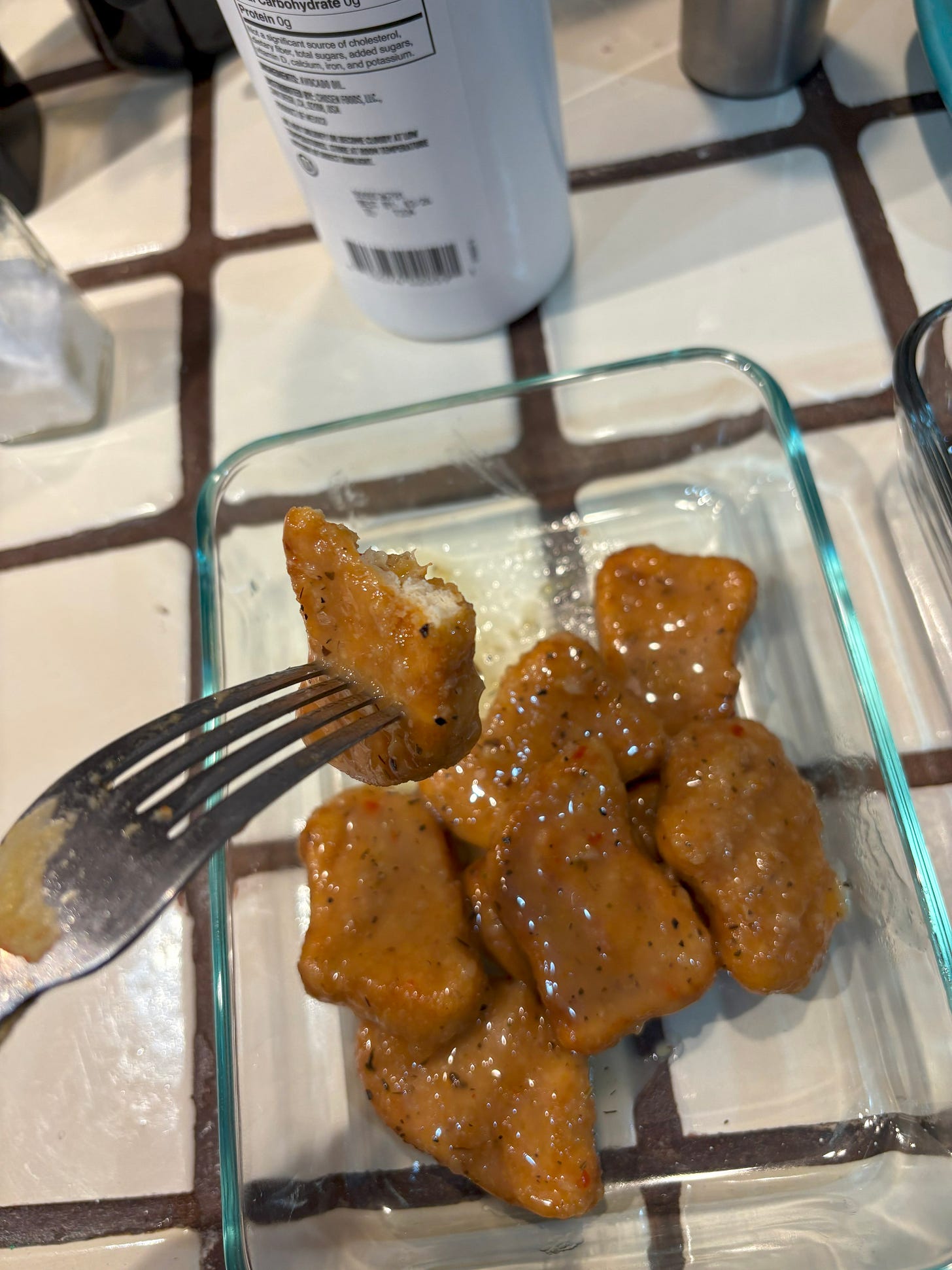 A chicken nugget swimming in garlic sauce