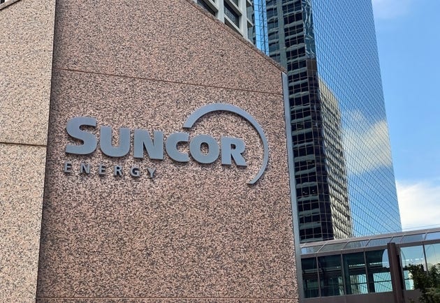 A close up to a Suncor sign with some building on the background. A close up to a Suncor sign with some building on the background.