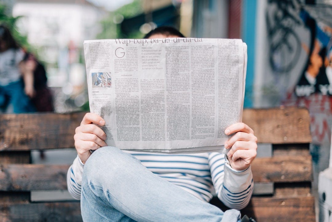man sitting on bench reading newspaper man sitting on bench reading newspaper