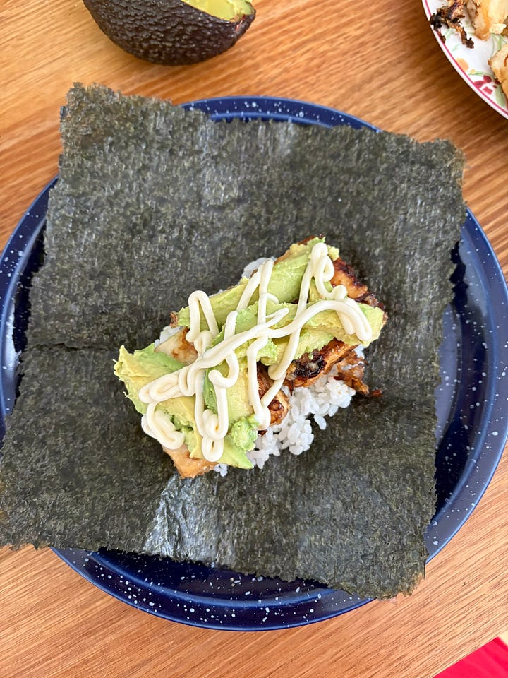 A toasted seaweed sheet with rice, teriyaki tofu, avocado and kewpie mayo. Half an onigirazu with teriyaki tuna, avocado and mayo.