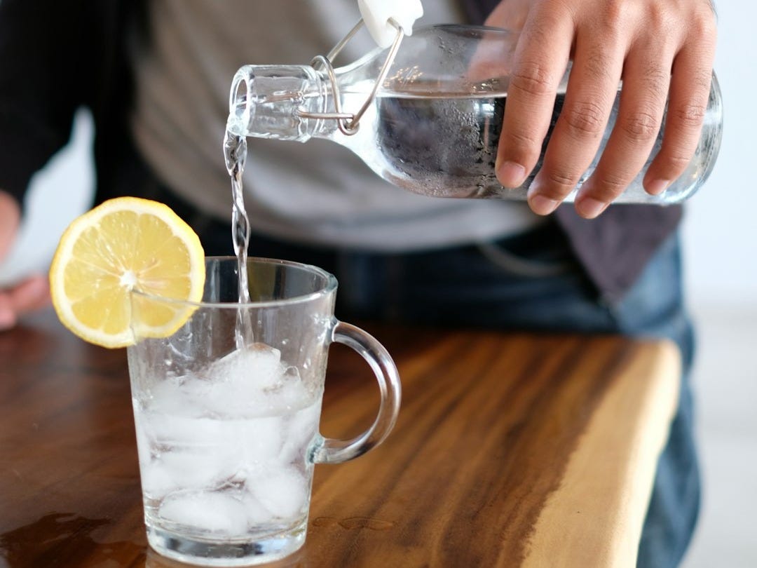 man pouring water in glass man pouring water in glass