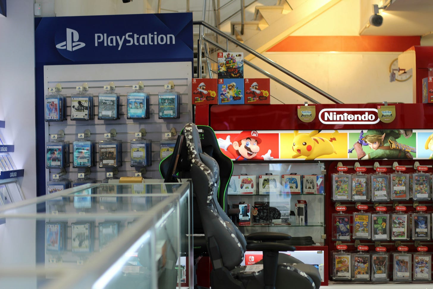 A video game store, with a glass counter and PlayStation and Nintendo games on hooks.