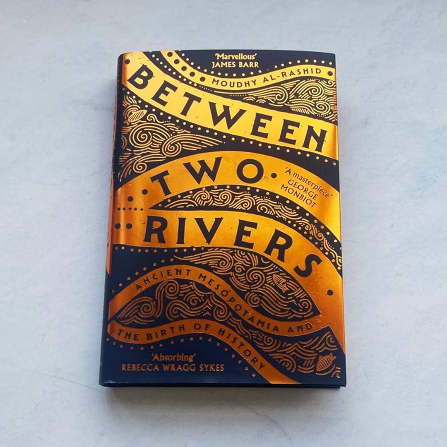 Book titled 'Between Two Rivers' with decorative cover on a light gray background