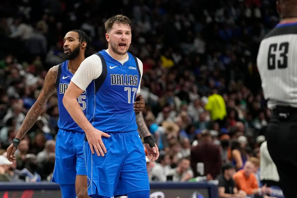 Dallas Mavericks guard Luka Doncic (77) is held by teammate Derrick Jones Jr. while disputing a call to referee Derek Richardson (63) during the second half of an NBA basketball game against the Oklahoma City Thunder in Dallas, Saturday, Dec. 2, 2023. (AP Photo/LM Otero)