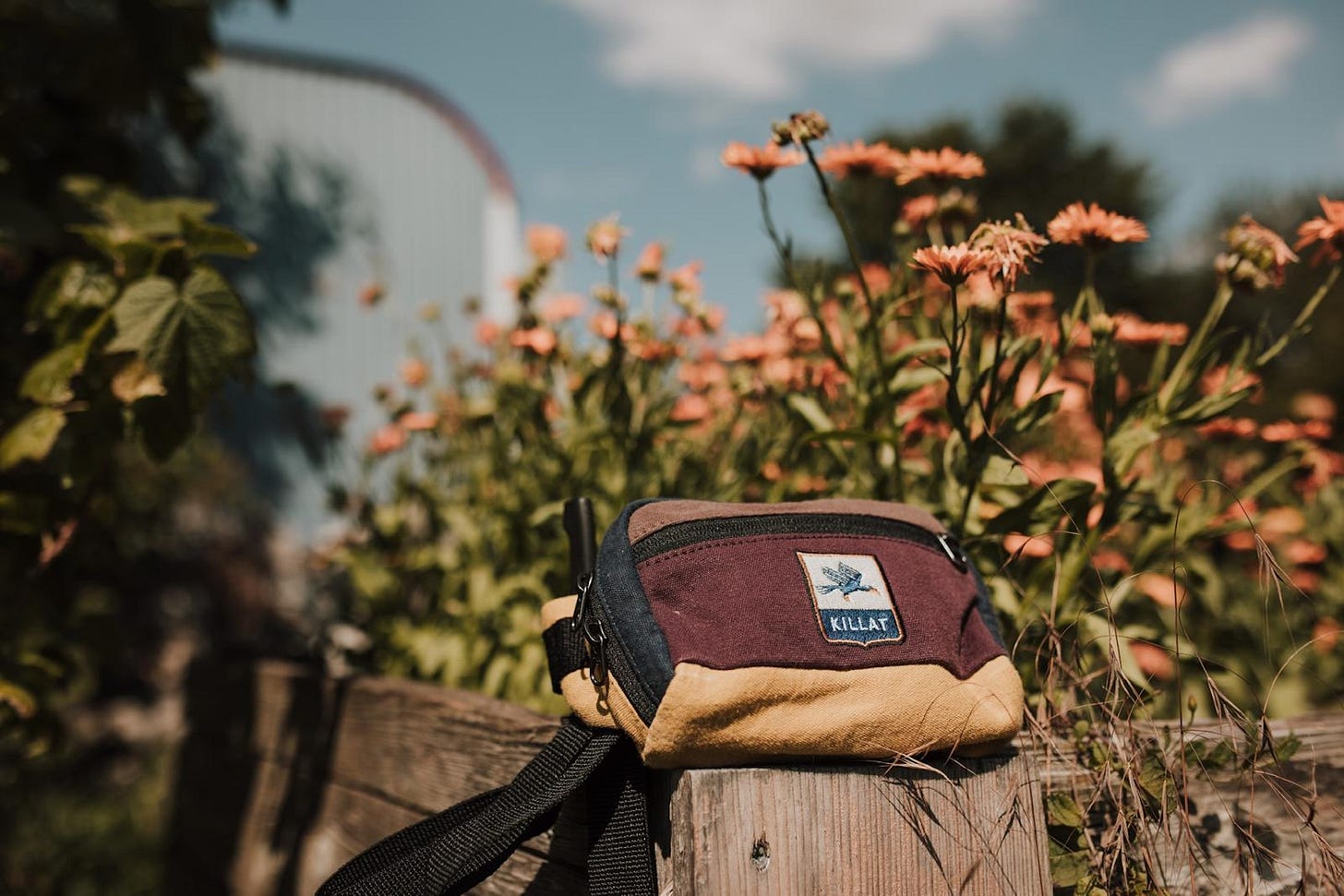 New Moon cotton hip bag on a fence with flowers in the background