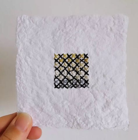 Cross stitch squares on handmade paper