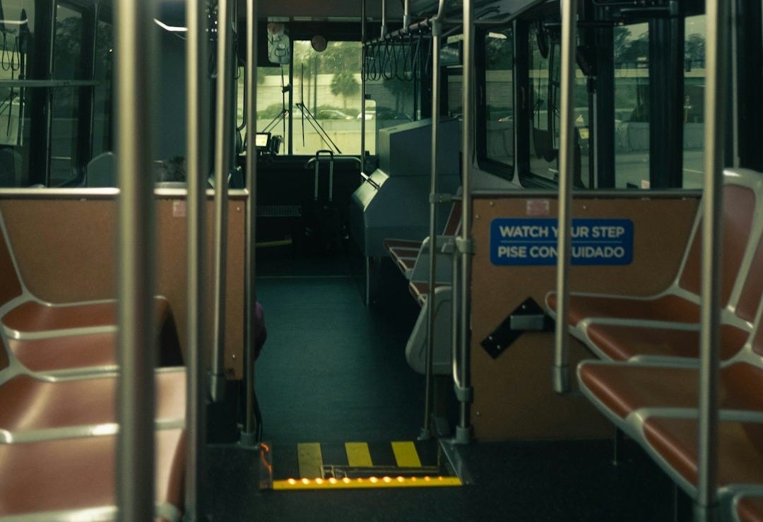 Interior view of an empty public bus during the day.