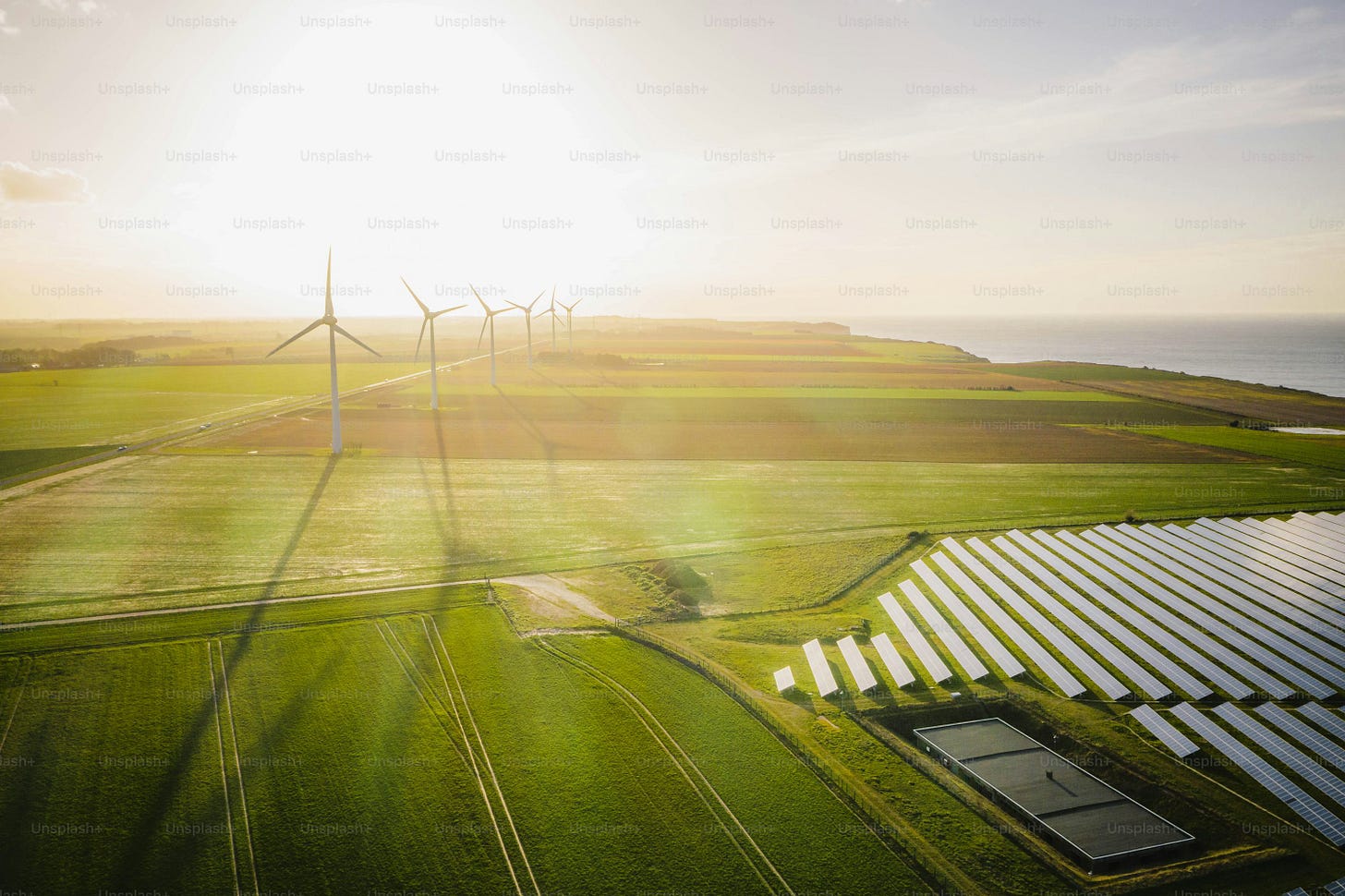 an aerial view of a wind farm near a body of water an aerial view of a wind farm near a body of water